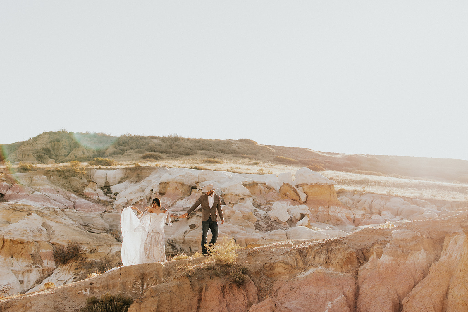 stunning couple holding hands with paint mines in the background