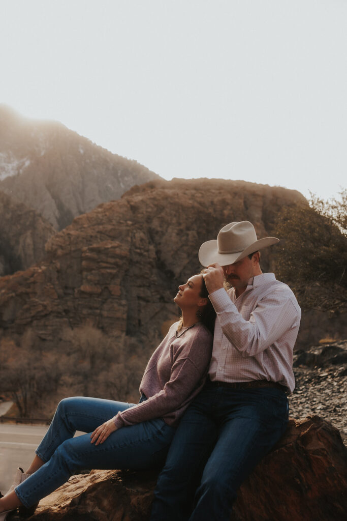amazing couple seating on a rock during their engagement session