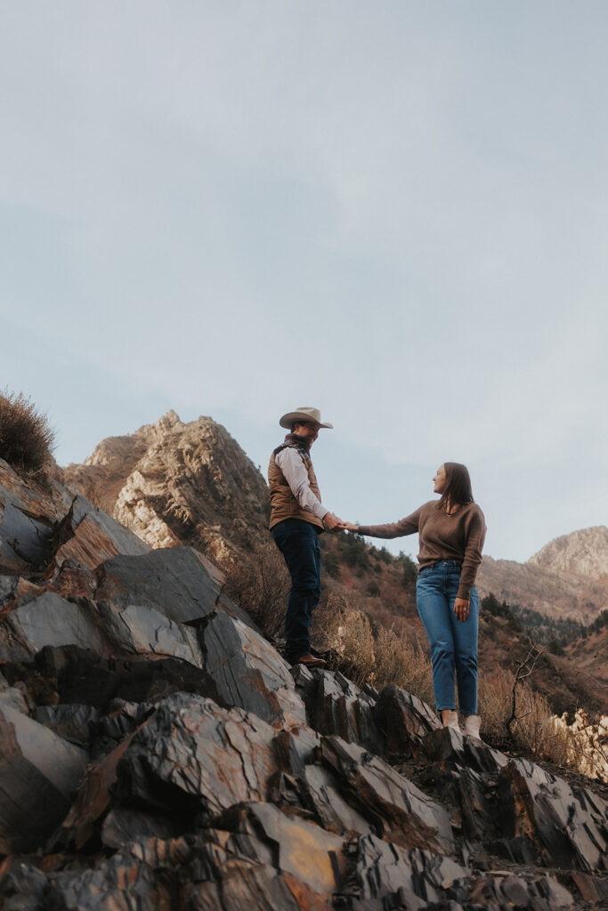 couple holding hands at storm mountain during their engagement session