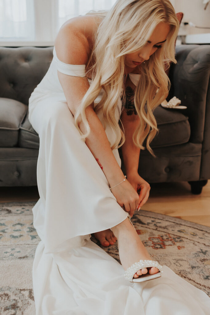 Bride putting on her heals before the ceremony for their intimate wedding