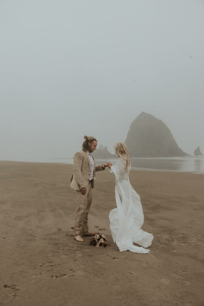 bride and groom exchanging rings at their cinematic beach elopement