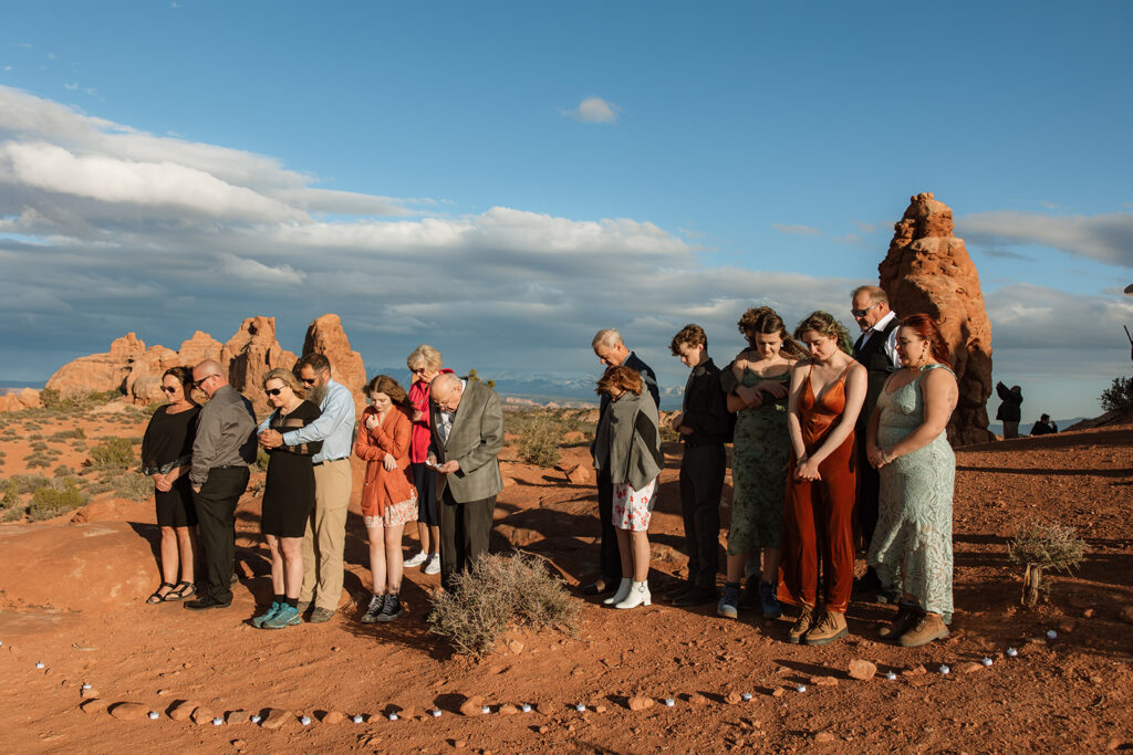 guests praying for the newly eloped couple