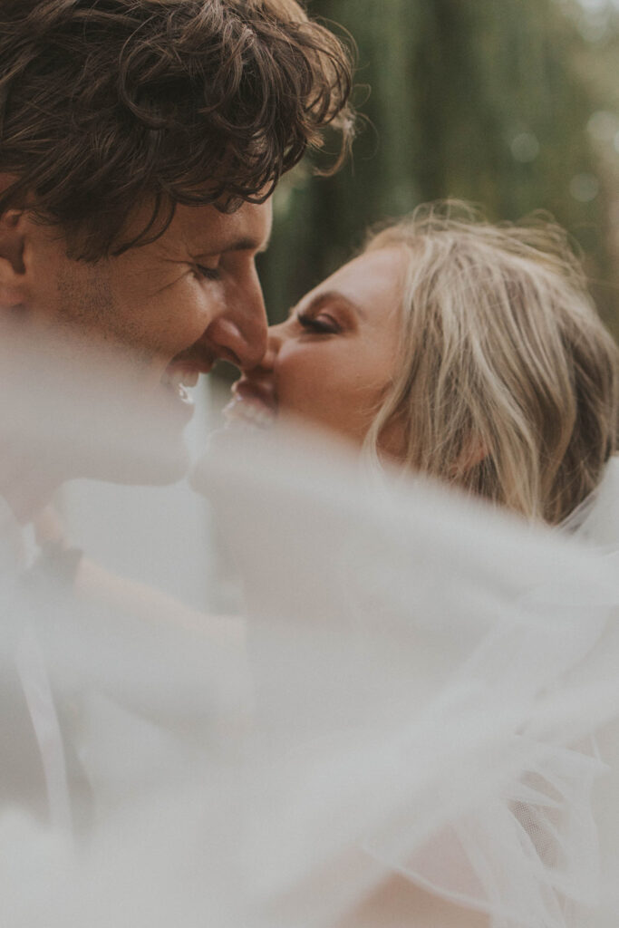 bride and groom smiling to each other 