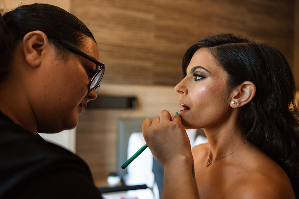 bride getting her makeup done for her Elegant and Adventurous Wedding 