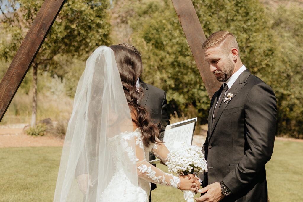 bride and groom holding hands at their wedding ceremony 