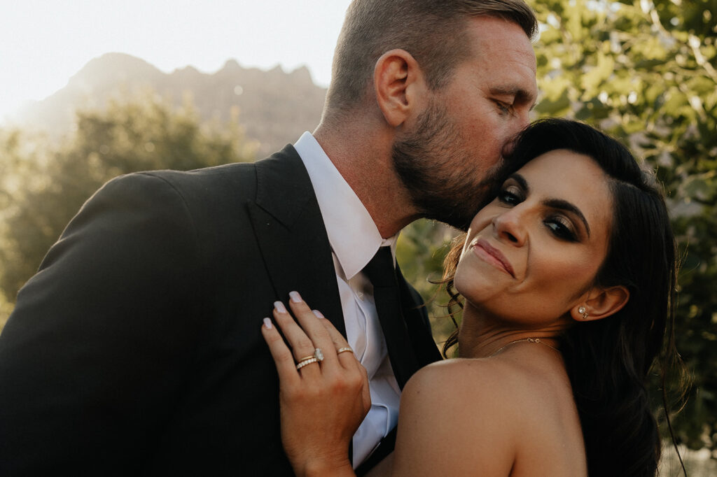 groom kissing the bride on the cheek