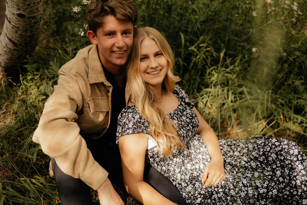 couple smiling at the camera during their romantic engagement session