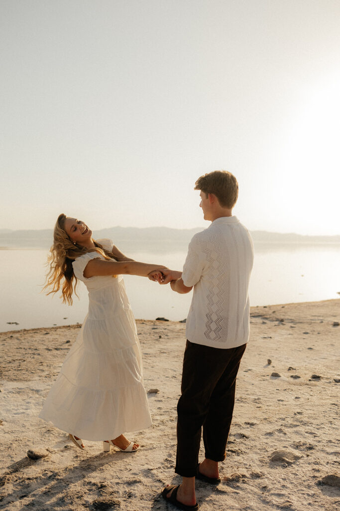 cute couple running around the beach 