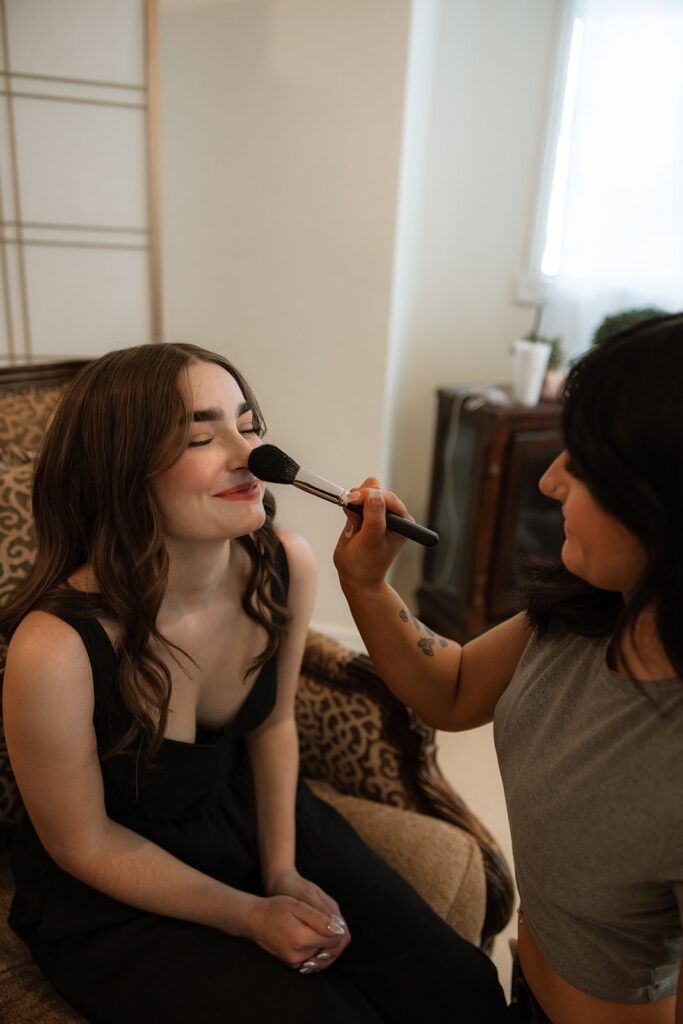 cute picture of the bride getting her makeup done for the ceremony