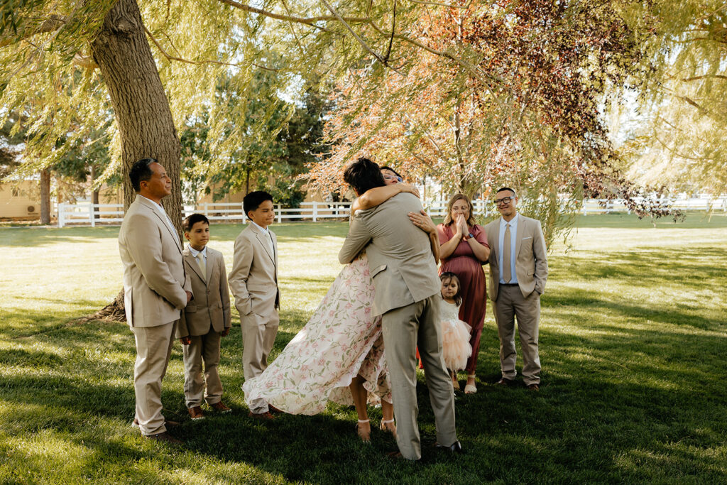 groom hugging his family during their first look
