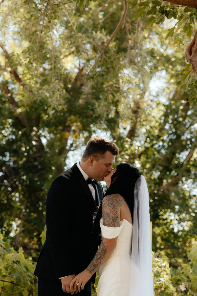 cute portrait of the bride and groom kissing after the ceremony