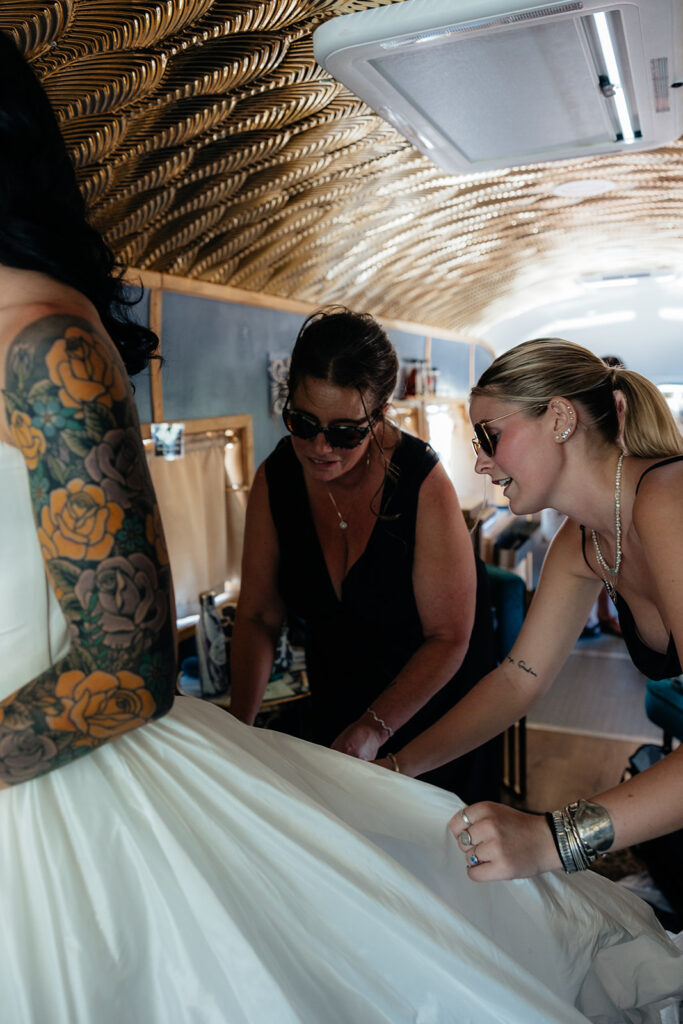 bridesmaids helping the bride with her wedding dress