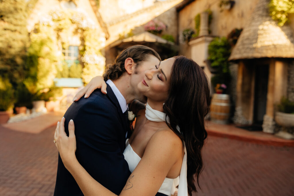 groom kissing the bride on the neck