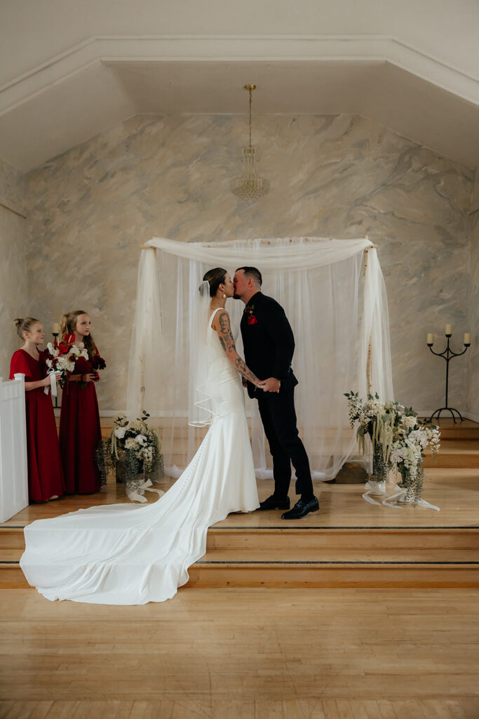 newly married couple kissing after their ceremony