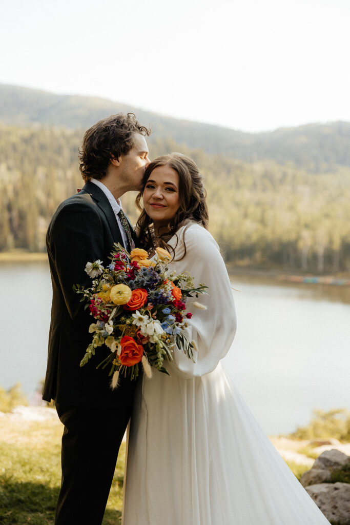 groom kissing the bride on the forehead