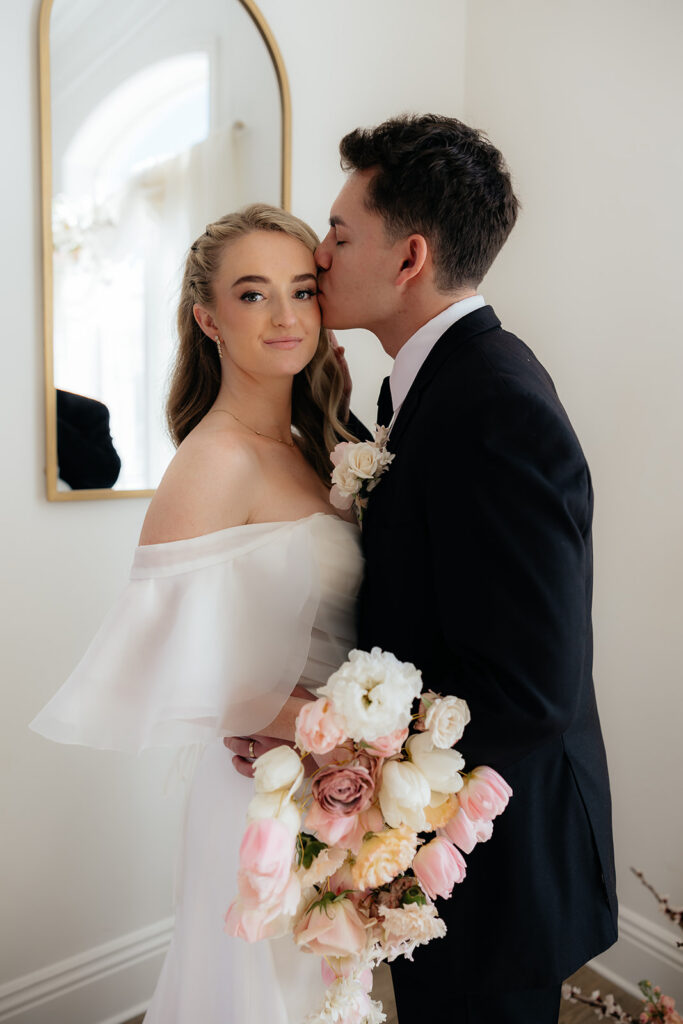 groom kissing the bride on the forehead