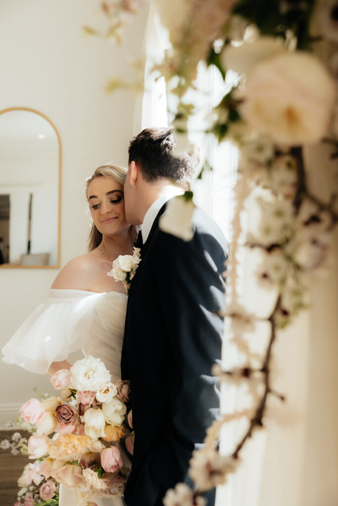 groom kissing the bride on the cheek