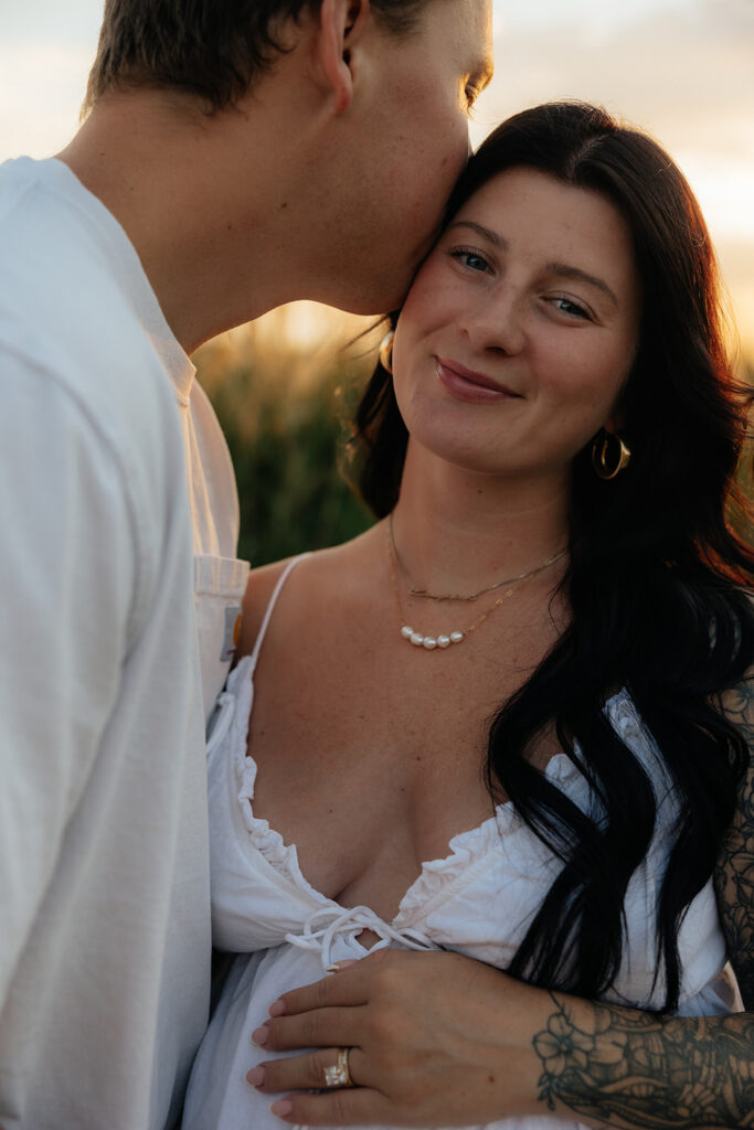 husband kissing his wife on the forehead
