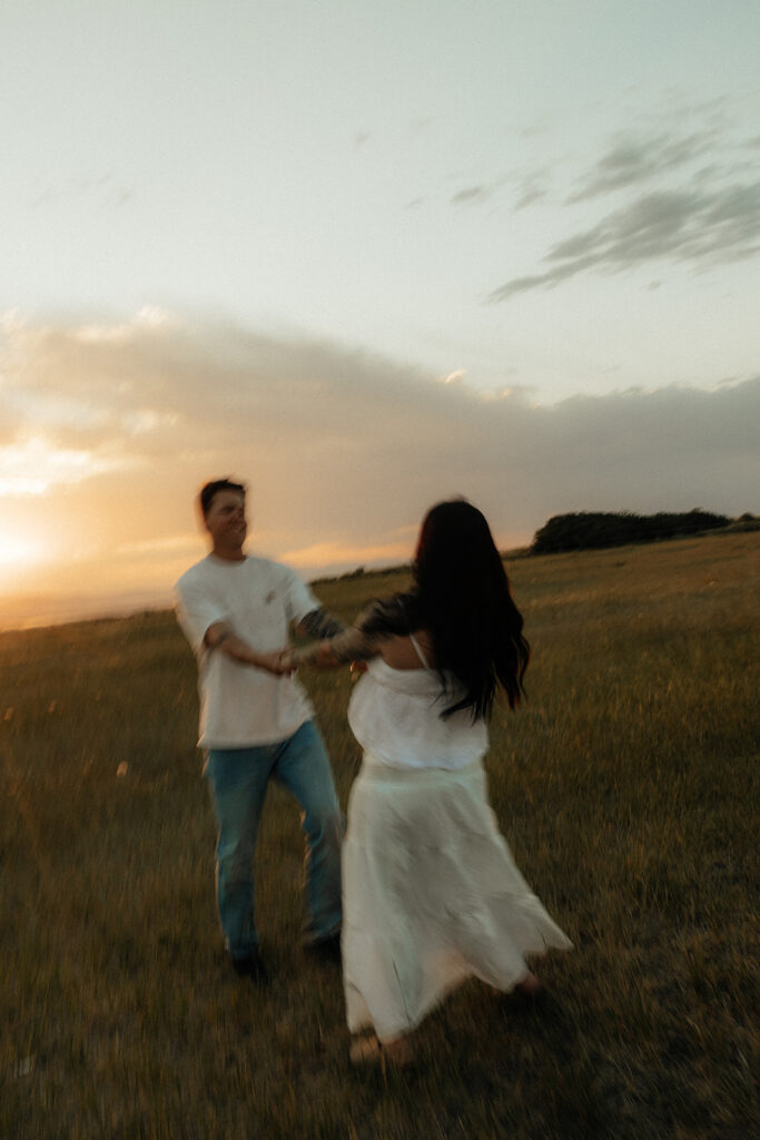couple at their playful maternity session in the mountains
