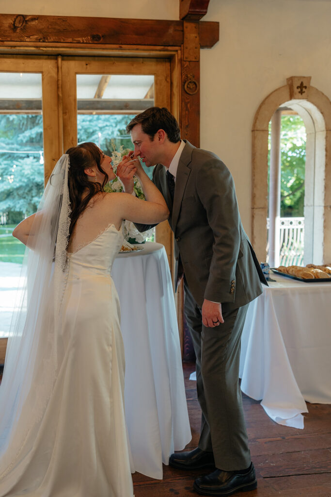 newlyweds trying their wedding cake